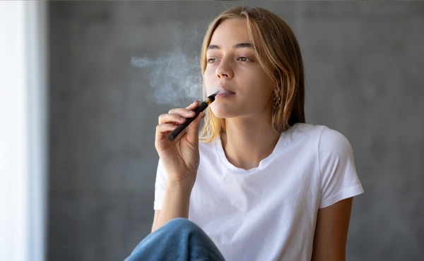 Девушка курит электронную сигарету
